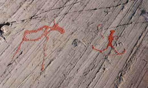 Petroglyph from Alta in Finnmark, Norway shows a skier on the right and a moose? on the left.